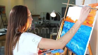 女艺术家跟随她的灵感，在晚上在她的工作室里画她的新画。